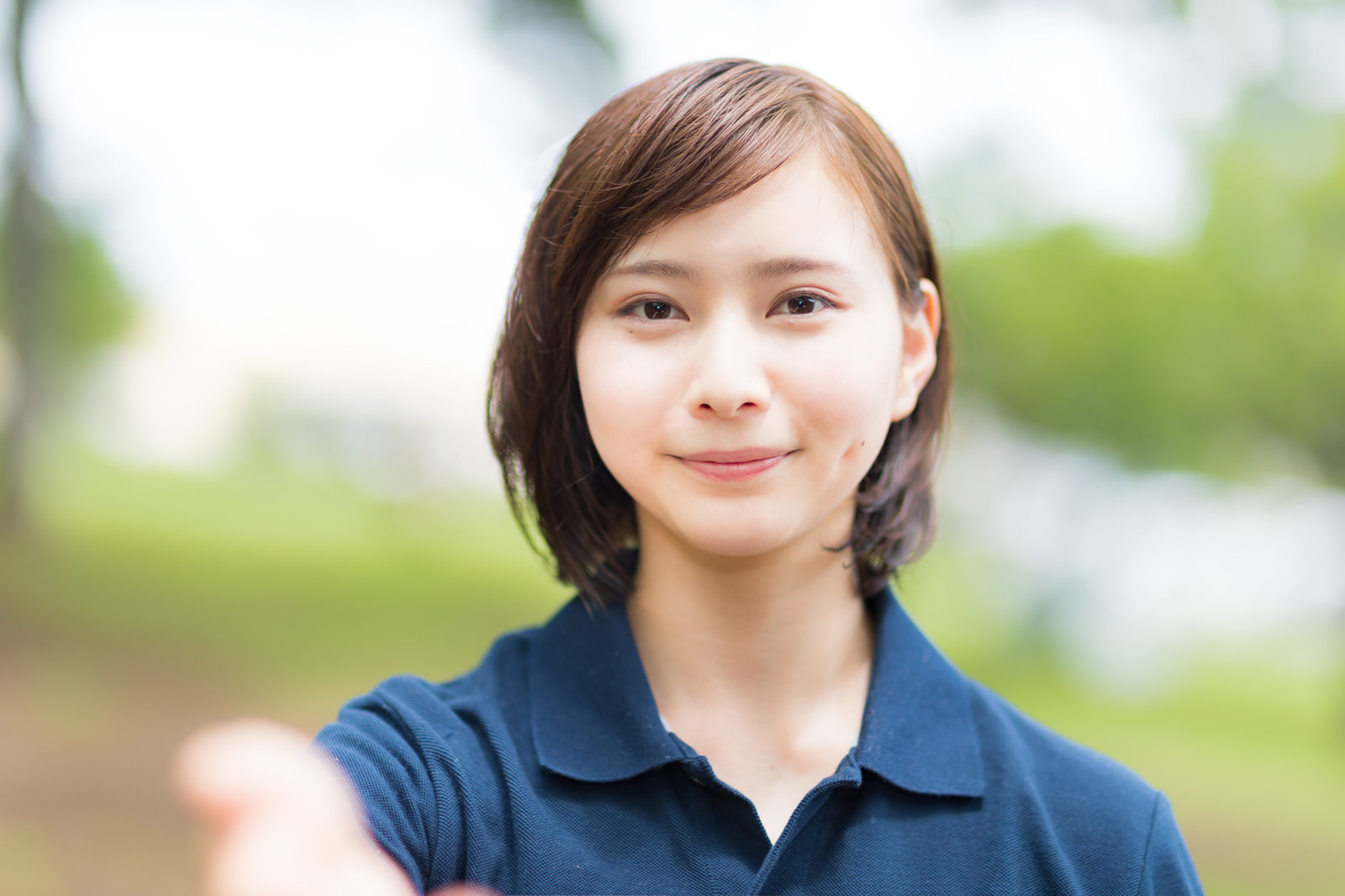カメラをまっすぐ見つめ、穏やかに微笑む女性スタッフ