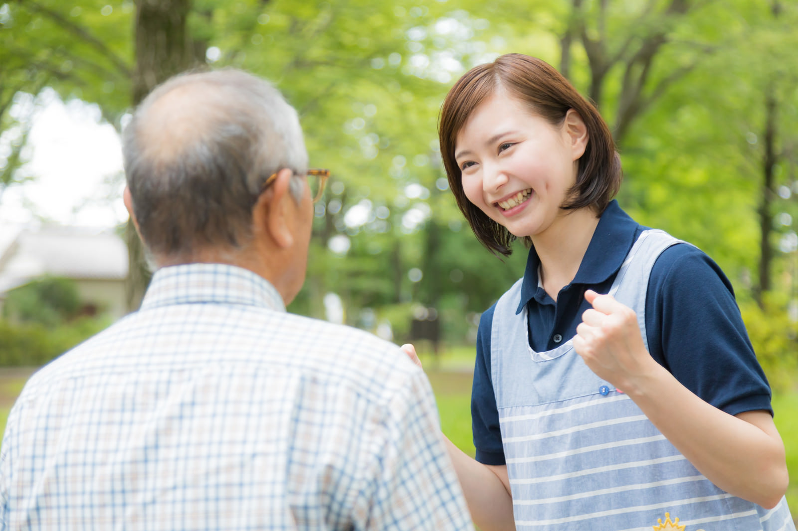 男性利用者に笑顔で話しかける女性介護スタッフ